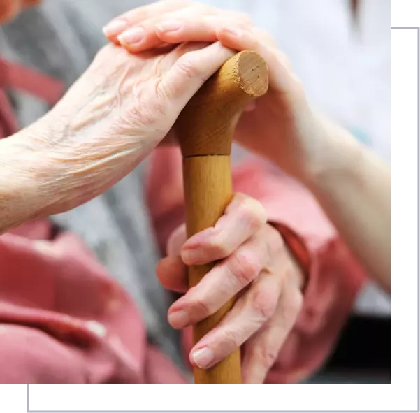 A person holding onto a cane while wearing gloves.